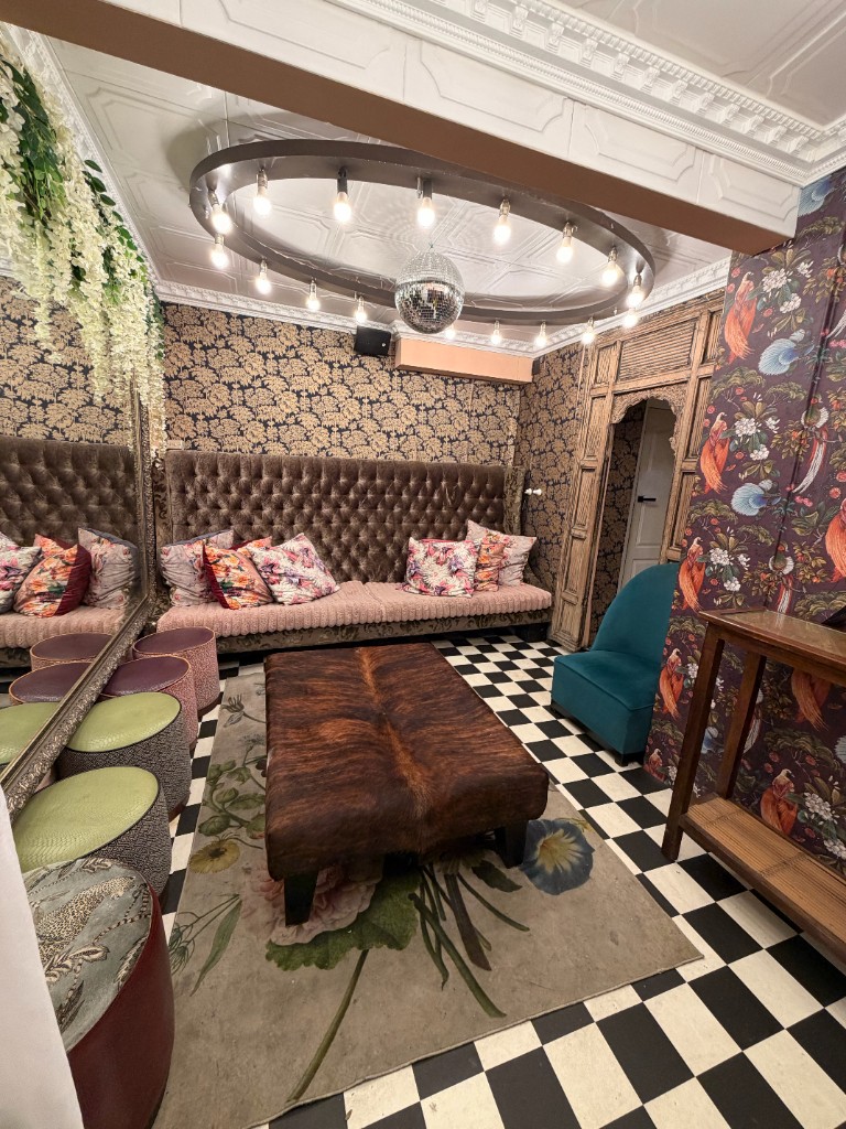 The Powder Room — gold damask lounge with disco-ball chandelier and velvet banquettes